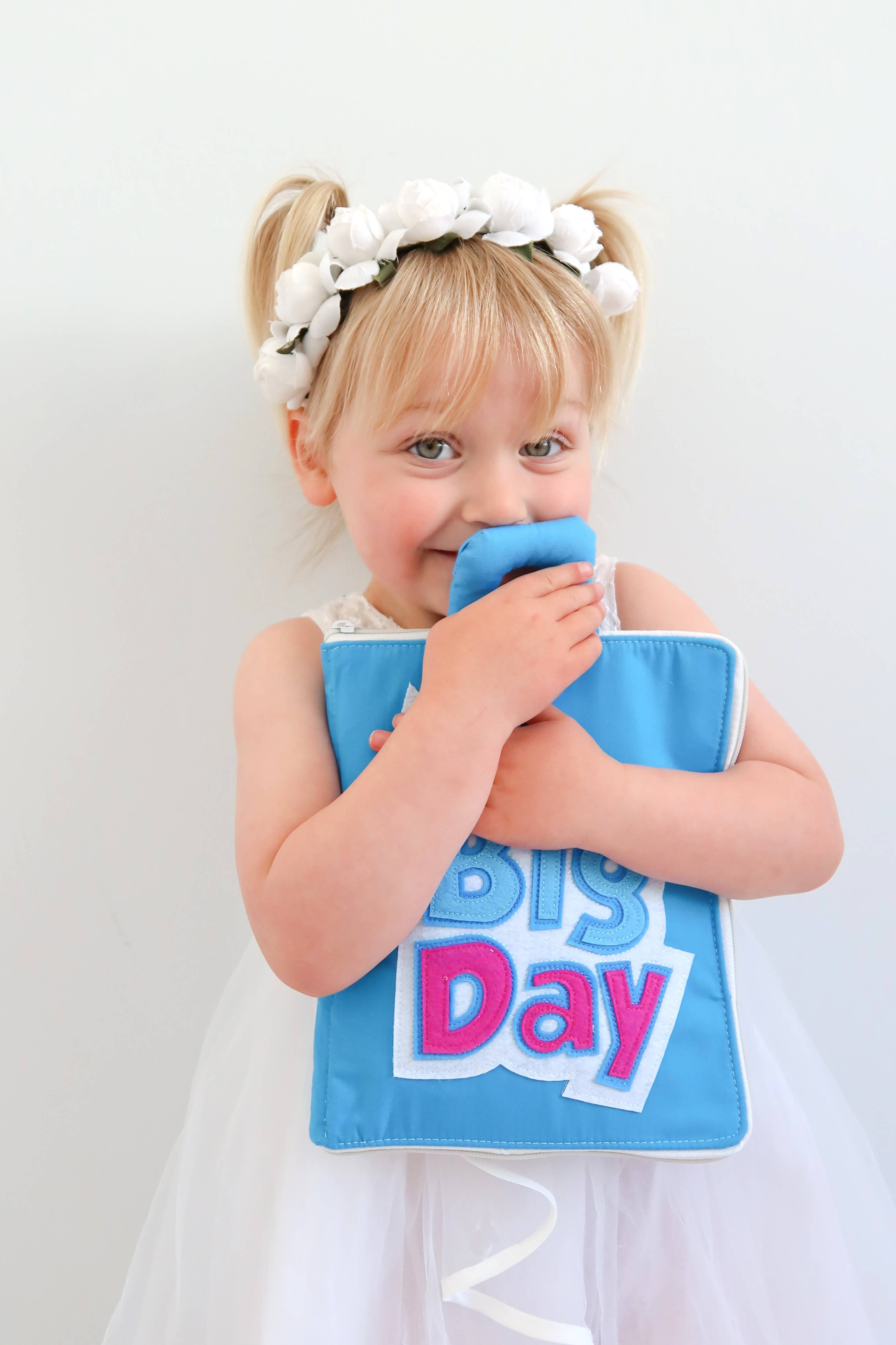 Child playing with My Big Day quiet book Montessori learning toy