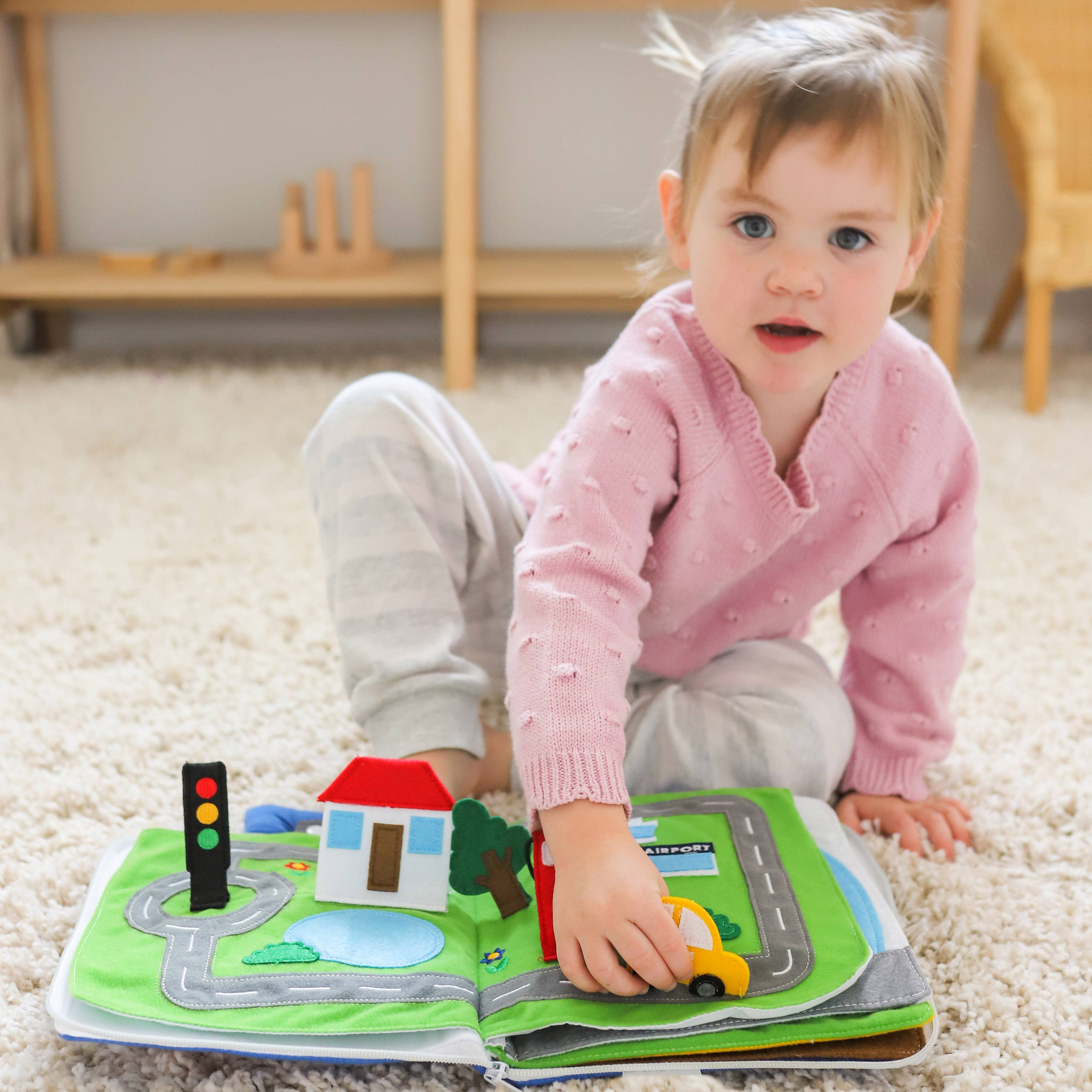 Toddler playing with Away We Go travel quiet book educational toy