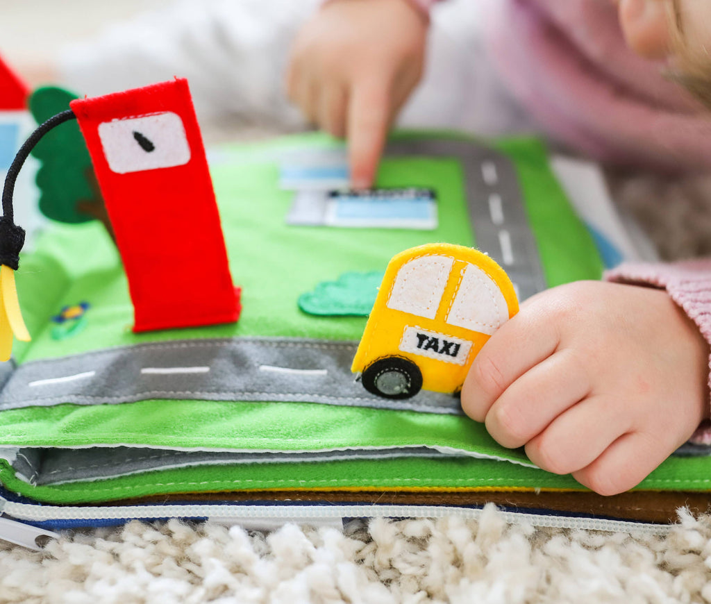 Toddler playing with Away We Go travel quiet book educational toy