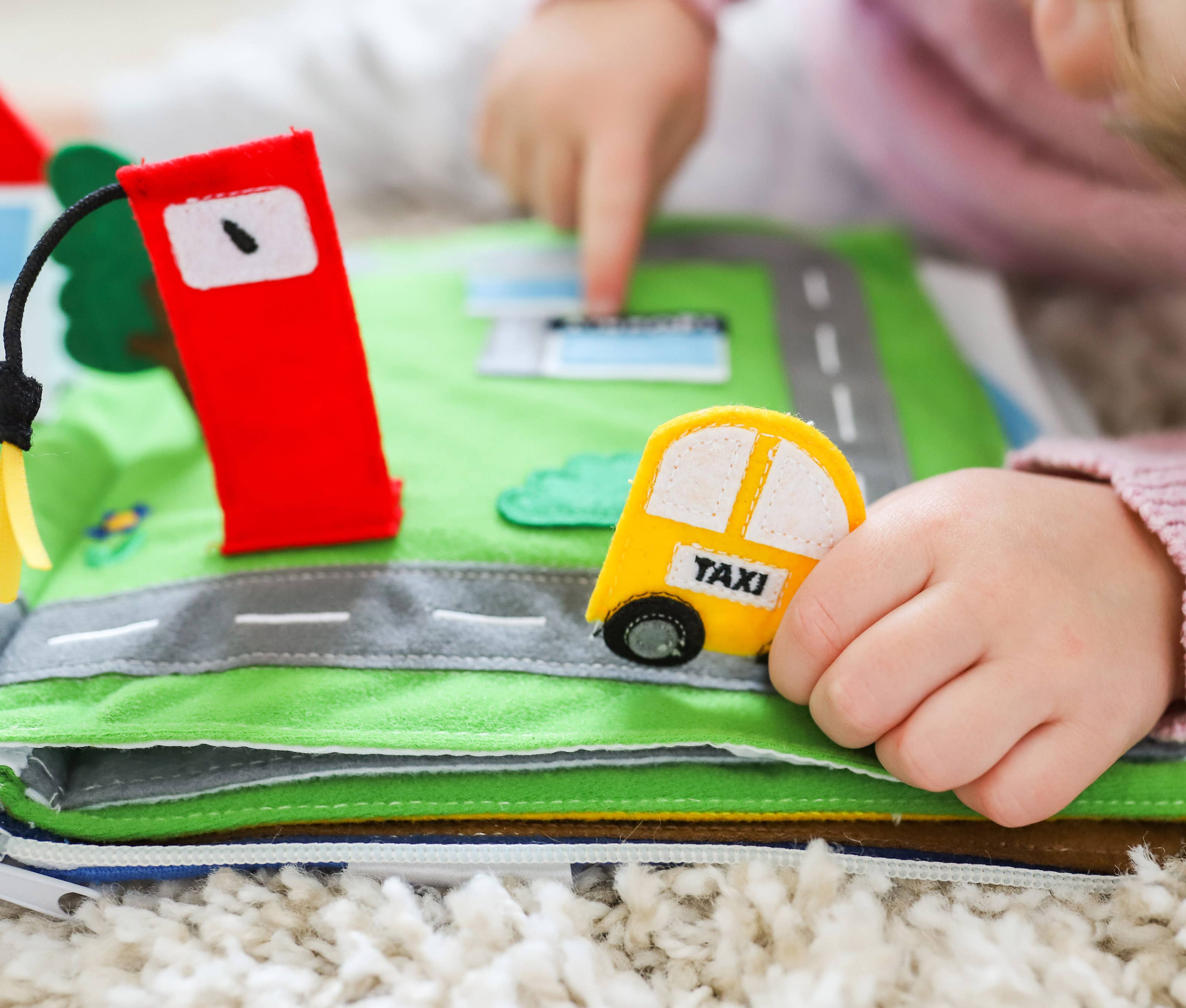 Toddler playing with Away We Go travel quiet book educational toy